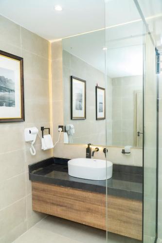 a bathroom with a sink and a shower at The Cordis Hotel, Ikeja in Ikeja