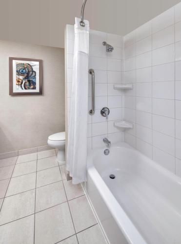 a white bathroom with a tub and a toilet at Fairfield Inn & Suites by Marriott Toronto Brampton in Brampton