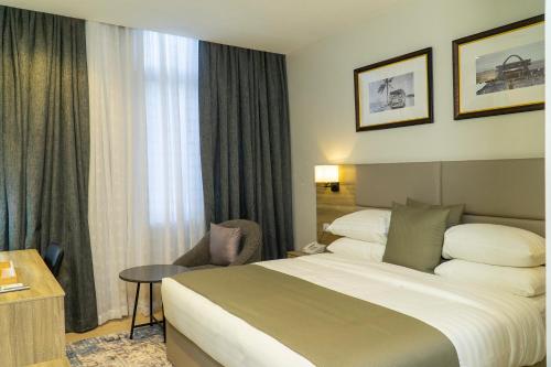 a hotel room with a large bed and a table at The Cordis Hotel, Ikeja in Ikeja