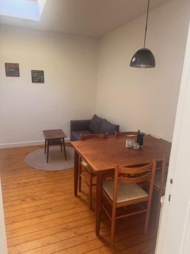 a living room with a wooden table and a couch at Havfruens Lejlighed in Rødby