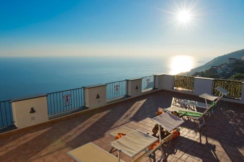 a balcony with chairs and a view of the ocean at Calipso Residence in Furore