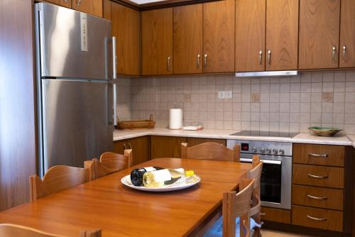 a kitchen with a wooden table and a stainless steel refrigerator at Casa Dimilia in Sívros