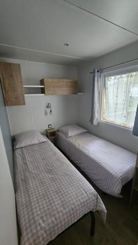 two beds in a small room with a window at Eden 1708 in Canet-en-Roussillon