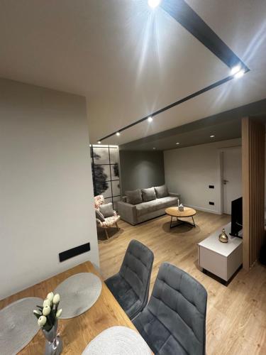 a living room with a couch and a table at Deluxe Aparthotel Central2 in Zalău