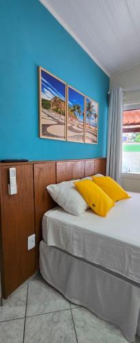 a bedroom with a bed with three pictures on the wall at Flats KENAI in Abraão