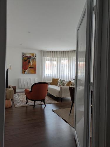 a living room with a couch and a chair at Apúlia Beach Avenue in Apúlia