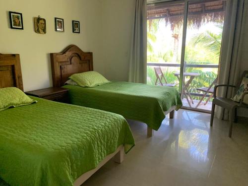 two beds sitting in a room with a window at Amazing 2 bedroom condo steps from the beach! in Playa del Carmen