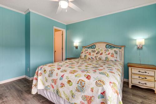 a bedroom with a bed with blue walls at Ocean-View Balcony! Myrtle Beach 3rd-Floor Retreat in Myrtle Beach