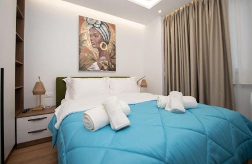 a bedroom with a blue bed with white pillows at Asinara Guatanamo Belmarsh in Durrës