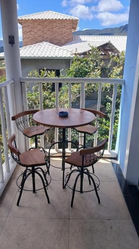a table and two chairs on a balcony at Casa Azul Marichi Hospedagem in Vale do Capao