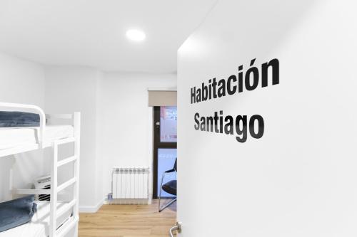 a dorm room with a bunk bed and a sign that reads education santiago at Albergue San Nicolás in Logroño