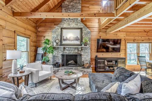 a living room with a stone fireplace and a tv at Luxury Lakefront Cabin in Castalian Springs