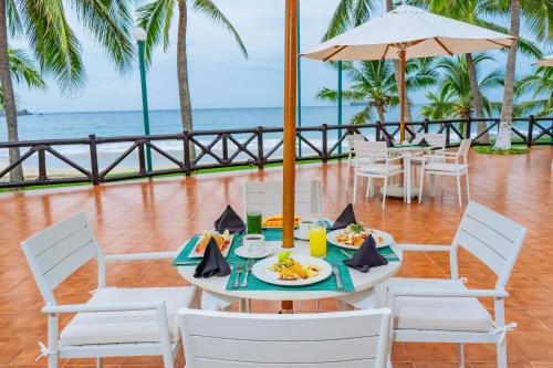a table with a plate of food and the ocean at Barceló Ixtapa - All Inclusive in Ixtapa