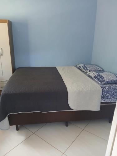 a bed in a room with a blue wall at Casa Azul Marichi Hospedagem in Vale do Capao