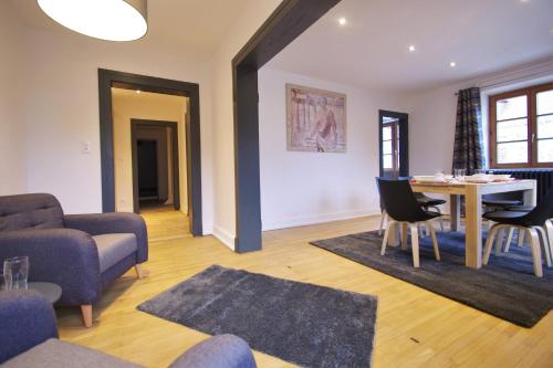 un salon avec un canapé, une table et des chaises dans l'établissement Le 21, à Mittelwihr