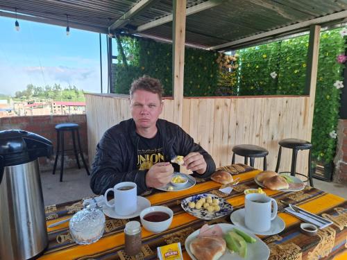 a man sitting at a table with food on it at HOTEL CHOQOLAqA RESTAURANT in Cabanaconde
