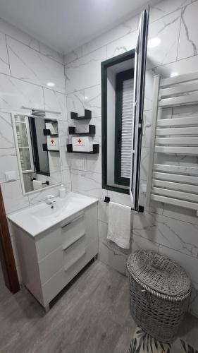 ein weißes Badezimmer mit Waschbecken und Spiegel in der Unterkunft Cais House in São Roque do Pico