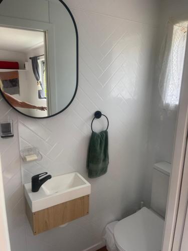 a bathroom with a sink and a mirror at Beach Bach Whangaumu Bay Tutukaka in Tutukaka