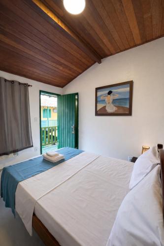 a bedroom with a large white bed with a window at Pousada Villas Boas Arraial do Cabo in Arraial do Cabo