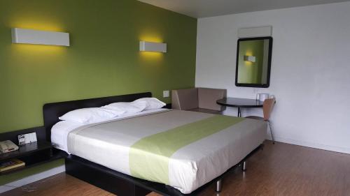 a bedroom with a large bed and a table at Bermuda Palms Hotel in San Rafael