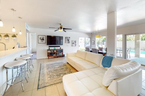 a living room with a white couch and a kitchen at Desert Retreat in Indian Wells