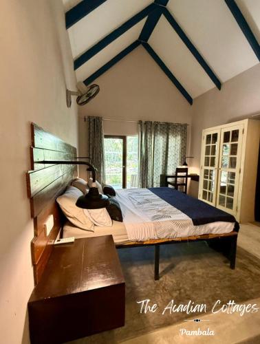 a bedroom with a large bed and a table at The Acadian Cottages in Madampe