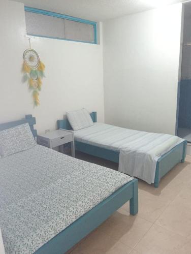 a room with two beds and a window at Hotel Danubio Azul in Yopal