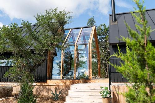 a glass house with stairs in front of it at Lagom Retreat in Dripping Springs