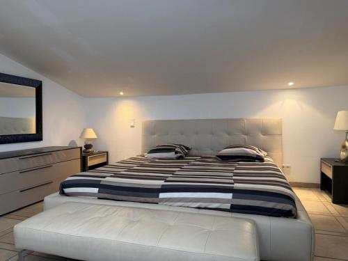 a bedroom with a large bed with a striped blanket at Villa avec piscine à Super Cannes in Vallauris