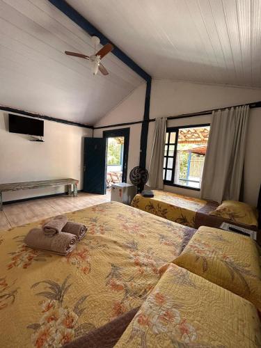 a bedroom with a large bed and a ceiling fan at Pousada Beira Rio Cipó in Serra do Cipo