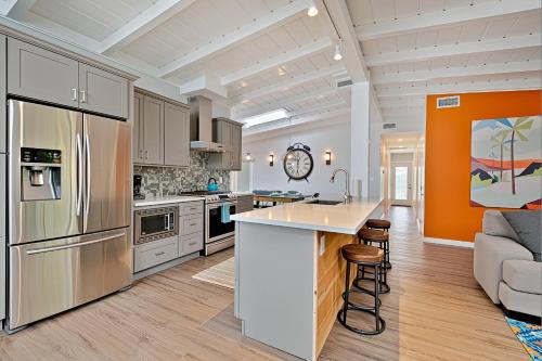 an open kitchen with an island and a couch at Shores Perfection - Spa, AC, Pet Friendly, Parking, Fire Pit & Massive Private Yard! in San Diego