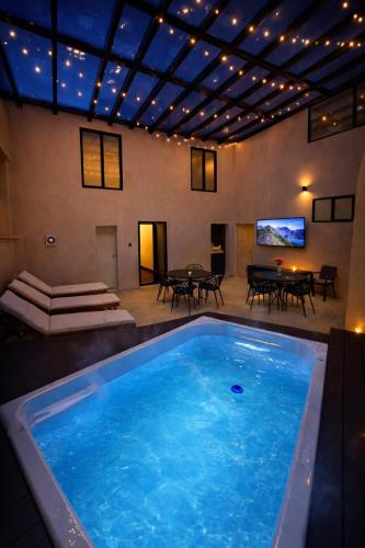 a large blue swimming pool in a room with a table at Suite privada en hotel Boutique in Bogotá