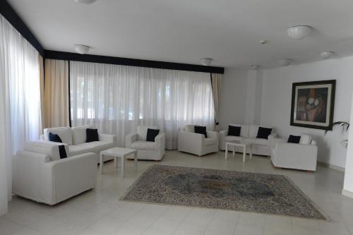 a living room with white couches and a rug at Pizzomunno Vieste Palace Hotel in Vieste
