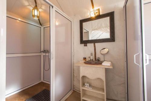 a bathroom with a mirror and a sink and a shower at Zahra Luxury Desert Camp in Merzouga
