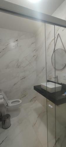 a white bathroom with a toilet and a sink at chácara vale do sol in Valença