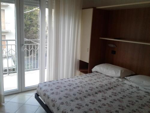- une chambre avec un lit et une grande fenêtre dans l'établissement Albergo Moderna, à Tabiano