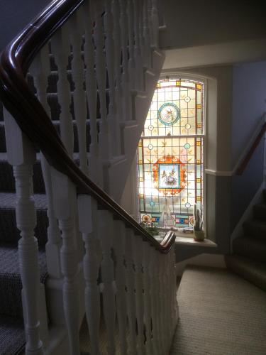 a staircase with a stained glass window in a house at Arduthie House in Stonehaven