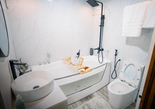 a white bathroom with a tub and a toilet at G-Luxe Panabo Guesthouse - Unit A in Panabo