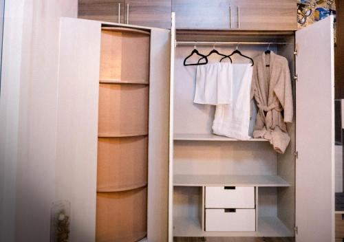 a walk in closet with white clothes on shelves at G-Luxe Panabo Guesthouse - Unit A in Panabo