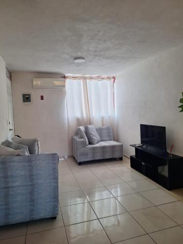 a living room with a couch and a television at Departamento cerca de la playa in Puerto Vallarta