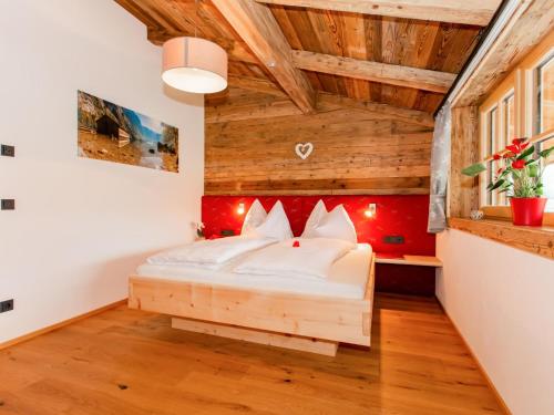 a bedroom with a bed in a room with wooden ceilings at Das Rendlgut Top 4 in Lofer