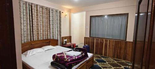 a bedroom with a bed and a large window at Vedanth Retreat Homestay in Kalimpong
