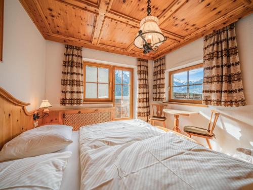 a bedroom with a bed and a desk and windows at Andre Top 2 in Wald im Pinzgau