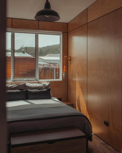 a bedroom with a bed and a window at The Rectory Zeehan in Zeehan
