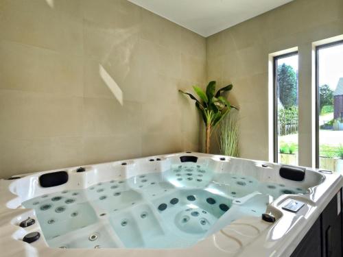 a white bath tub in a bathroom with a window at Villa with Pool & Suites for 12 Guests in Durbuy
