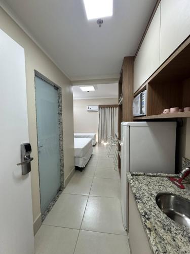 a kitchen with a sink and a room with a bed at Spazzio diRoma com acesso ao Acqua Park in Caldas Novas