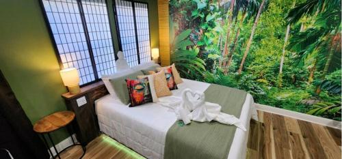 a bedroom with a bed with a tropical mural on the wall at Zen Retreat-Jacuzzi, kitchenette, Walk to fun in Reno