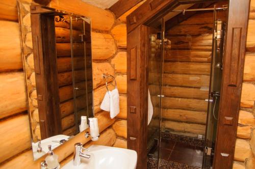 ロストフ・ナ・ドヌにあるHotel Tet-a-Tetのバスルーム(洗面台、ガラス張りのシャワー付)