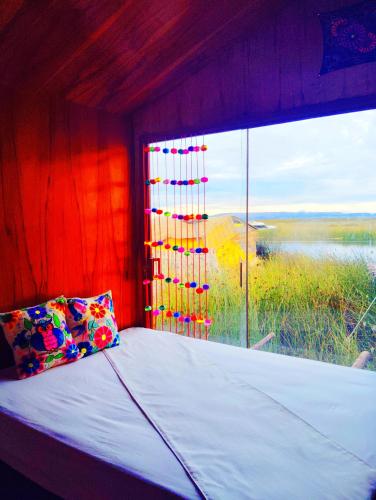 a bed in a room with a large window at Titikaka sky view lodge in Puno