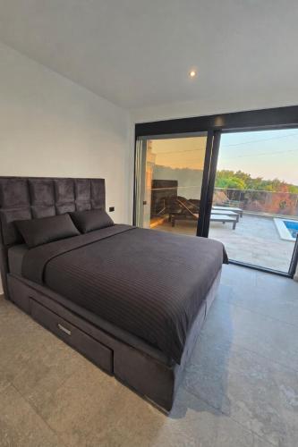 a bedroom with a large bed and a large window at Vila SOL DEL MAR in Utjeha